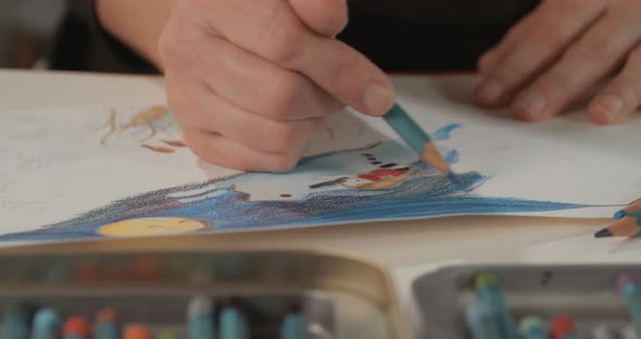 Female artist painting in her studio with water colors and pencils