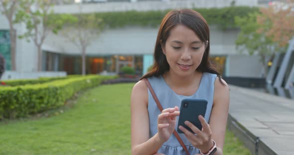 Woman look at the mobile phone in park