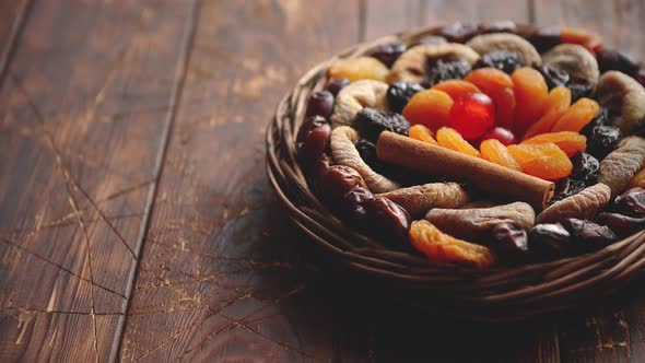 Mix of Dried Fruits in a Small Wicker Basket on Wooden Table