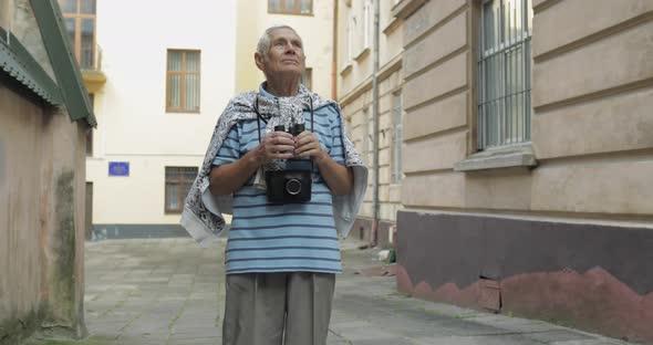 Senior Man Tourist Exploring Town. Looking in Binoculars. Travel Lviv, Ukraine