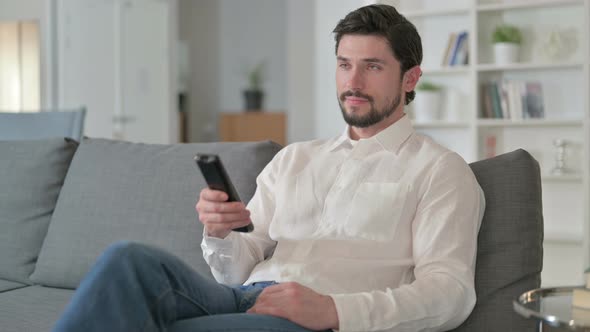 Attractive Man Watching Television at Home