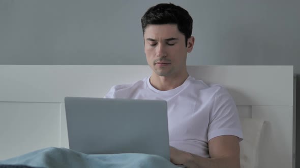 Young Man Working on Laptop in His Lap