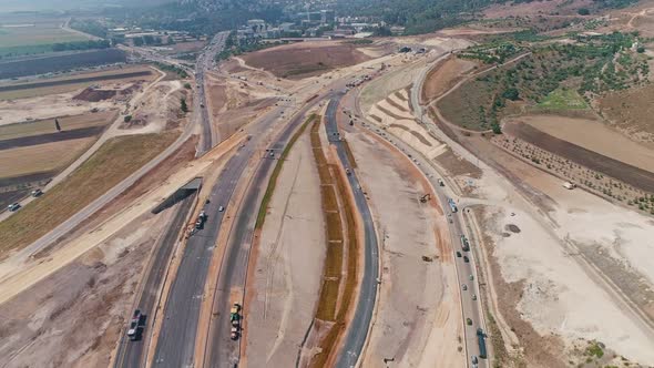 Aerial footage of large highway construction project with tunnels and bridges