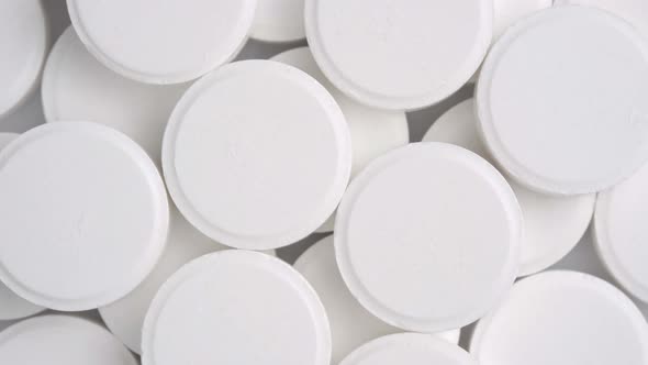 Many White Medical Pills Rotating Close Up Top View