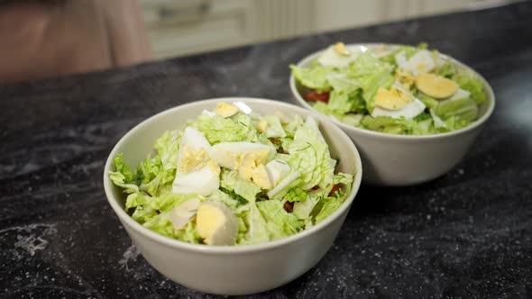 Person Spices Fresh Salad in Bowls with Fragrant Seasonings