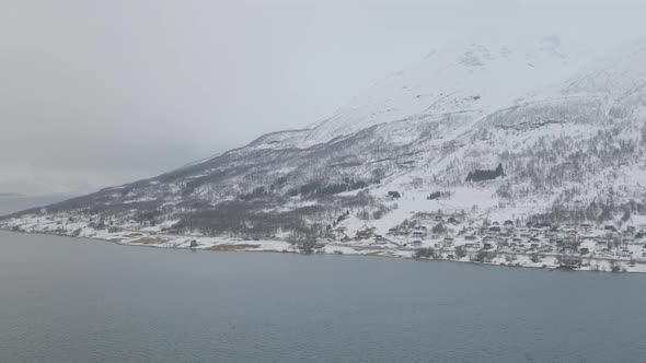 Kåfjord town and harbour by the foot of the mountain in Olderdalen, Norway. Overcast winter weather.