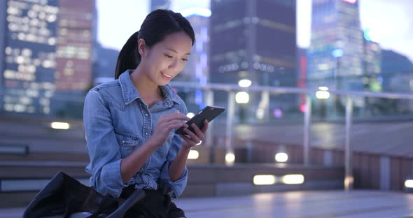 Woman looking at cellphone in the street