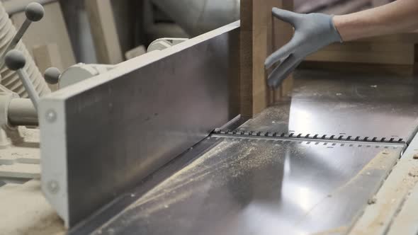 Male Carpenter Using Plane in Woodworking Woodshop