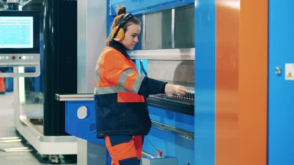 Female Operator is Using an Industrial Machine to Bend Aluminum