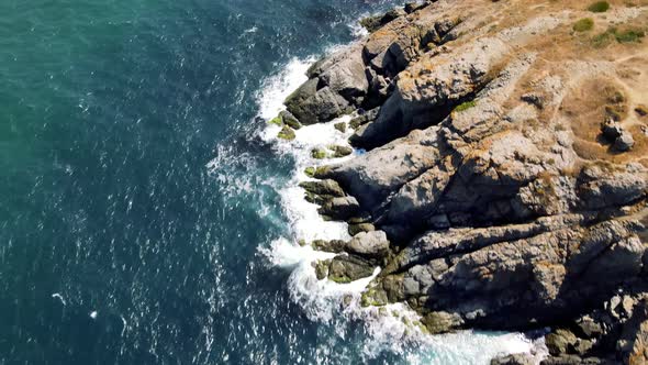 waves crashing cliffs view from drone shot