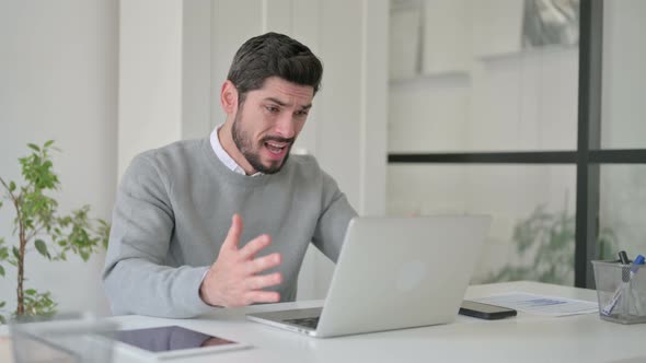 Young Man Reacting to Loss While Using Laptop