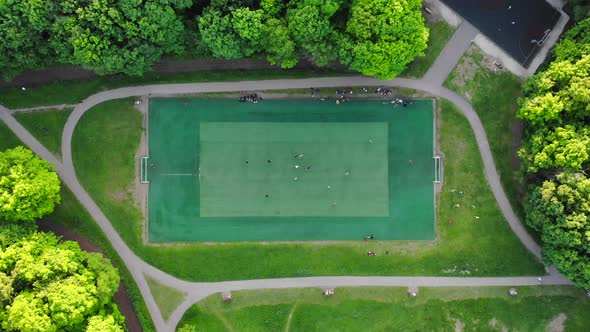 Aerial View of Men Playing Football on a Public City Soccer Field