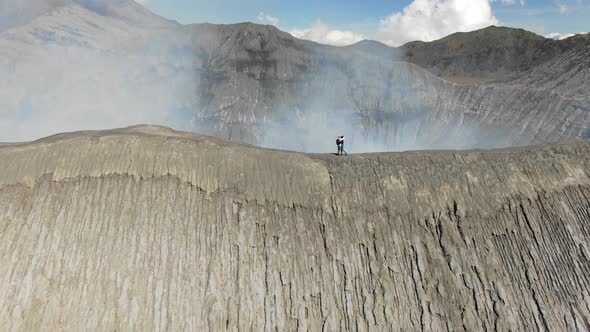 Couple hugging on ridge of Mount Bromo volcano