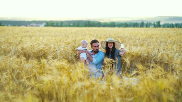 Female vlogger with husband and baby streaming from wheat field