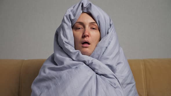 Sick Woman Wrapped in Grey Warm Blanket Coughs Heavily