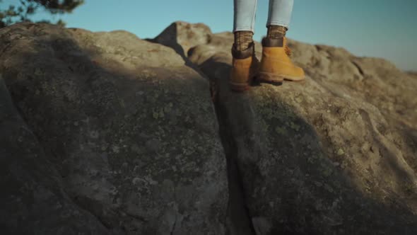 Slow Motion Faceless Side View Woman Hiker in Blue Jeans and Yellow Hiking Boots Climbing on Top of