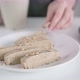 Blurred young woman in shirt drinks tea from white cup and eats brown halva slice - VideoHive Item for Sale