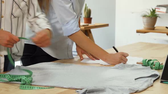 Fashion Designers Measuring T-shirt, Working at Their Workspace