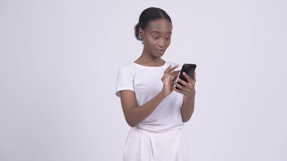 Happy Young Beautiful African Woman Using Phone and Getting Good News