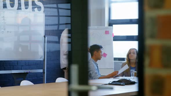 Business executives discussing over whiteboard