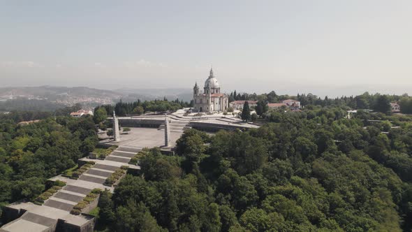 Hilltop Sameiro Sanctuary surrounded by lush forest, Braga, Portugal. Aerial establisher