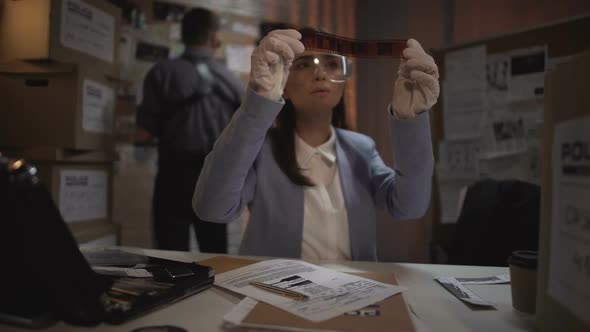 Experienced Scientist Looking at the Criminal Scene Photos, Drawing Conclusions