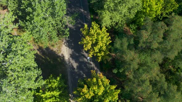 Aerial Tracking Shot of Runner Jogging on Forest Road
