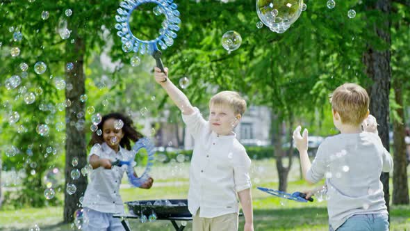 Little Children Playing with Soap Bubbles at Summer Day alt