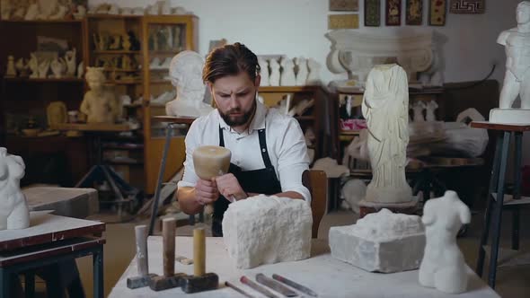 Young Master with Well-Groomed Beard Scraping the Remains of Limestone with the Brush