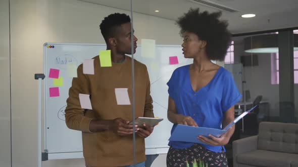 African american male and female business colleagues brainstorming in meeting room