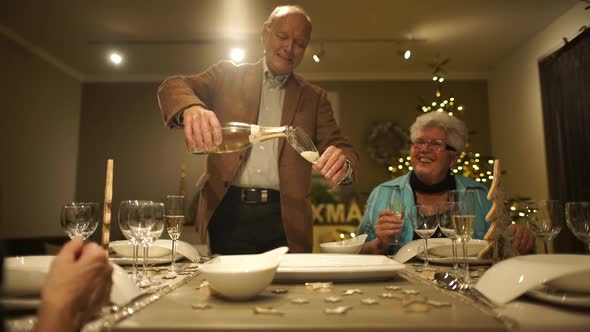 Senior Man Pouring Champagne in Glass