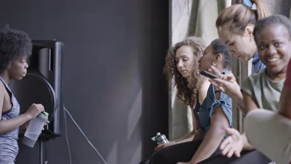 Women Sitting on Windowsill and Chatting