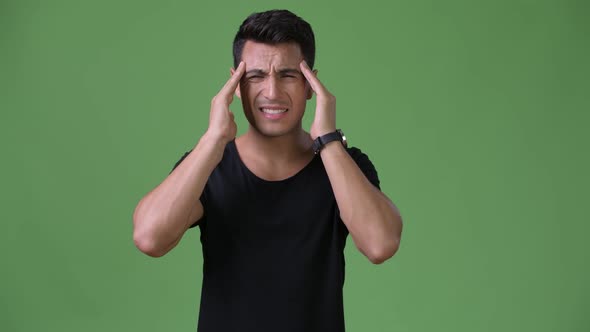 Young Handsome Hispanic Man Against Green Background