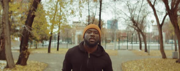 Black Man Running in Park on Autumn Day