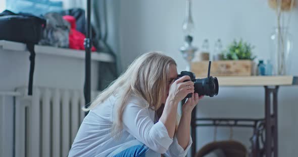 Professional Photographer Takes Photos on Camera Looks Into the Lens