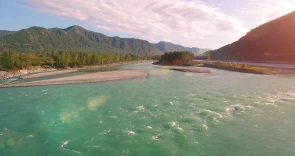 UHD Aerial View. Low Flight Over Fresh Cold Mountain River at Sunny Summer Morning. Green Trees and