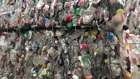 Low Angle Pan Up View Of Pressed Cubes Of Plastic Bottles Stacked Outside In Recycling Plant