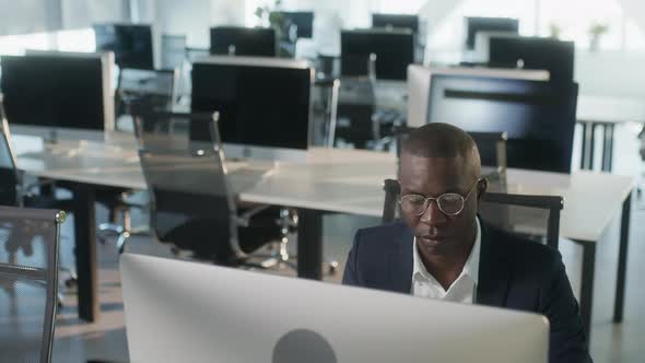 Serious African American Employee Thinking Over Business Email Working on Computer in Office Focused