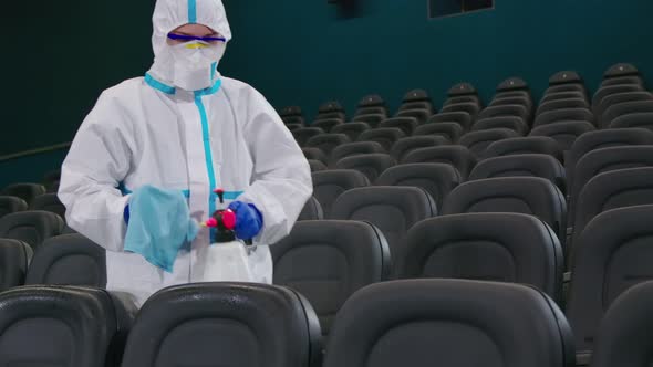 Male Cleaner Making Disinfection of Chairs at Cinema