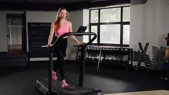 Woman athlete running on treadmill, doing cardio workout in gym