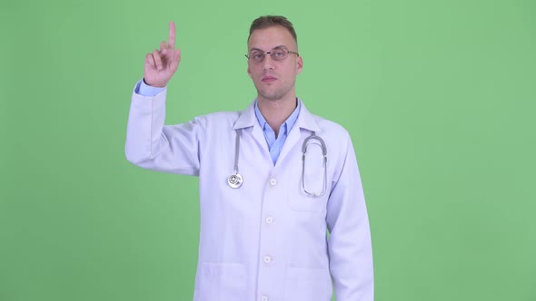 Happy Handsome Man Doctor Pointing Up