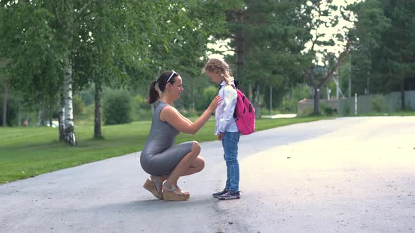 Woman Saying Goodbye to Daughter Before School