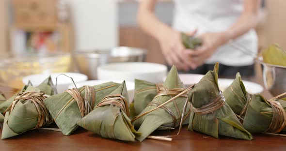 Woman make chinese sticky rice dumpling for dragon boat festival