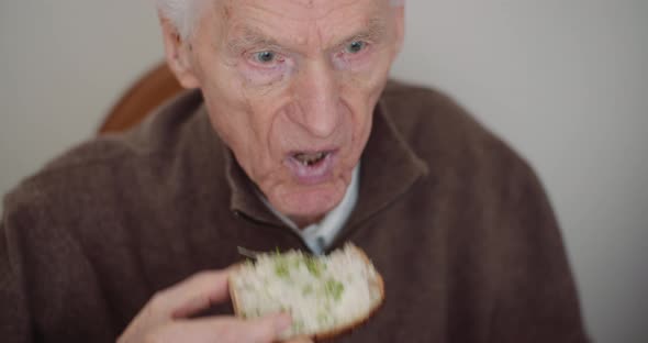 Retirement - Senior Man Eating Sandwitch.