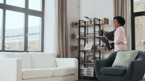 Woman Arranging Cushions at Home