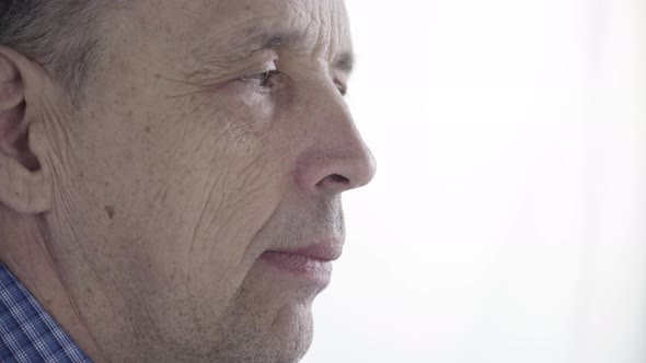 Elderly Man Drinks Coffee or Tea From a Porcelain Mug