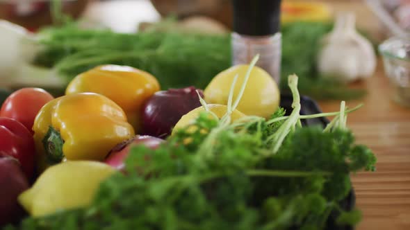 Lots of vegetables, cooking ingriedients and spices lying on a kitchen table