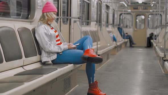 The Funny Attractive Joyful Blonde Girl Dancing in a Subway Car in Underground Metro. The Woman Is