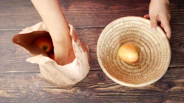 Taking Apple Out From a Paper Shopping Bag