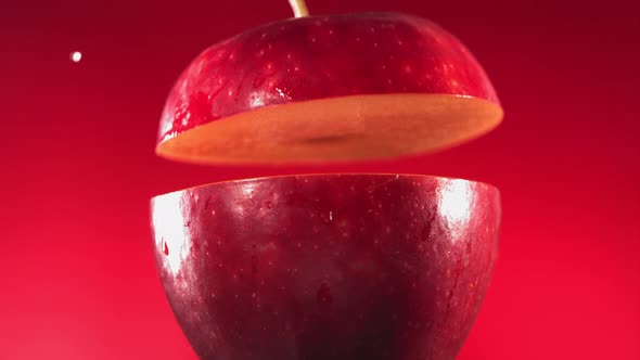 Half Red Apple Falling and Splashing on Fuchsia Red Background